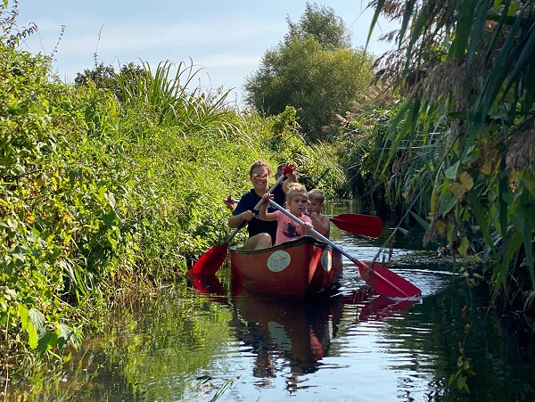 Familie kanoet samen door het kanaal. 