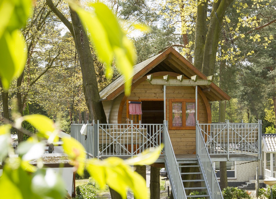 Een sfeervol huisje hoog tussen de bomen. Zo lijkt het op een boomhut. 