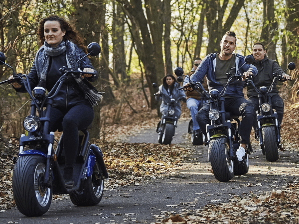 Een groep mensen zijn in het bos aan het rijden met de e-choppers. 